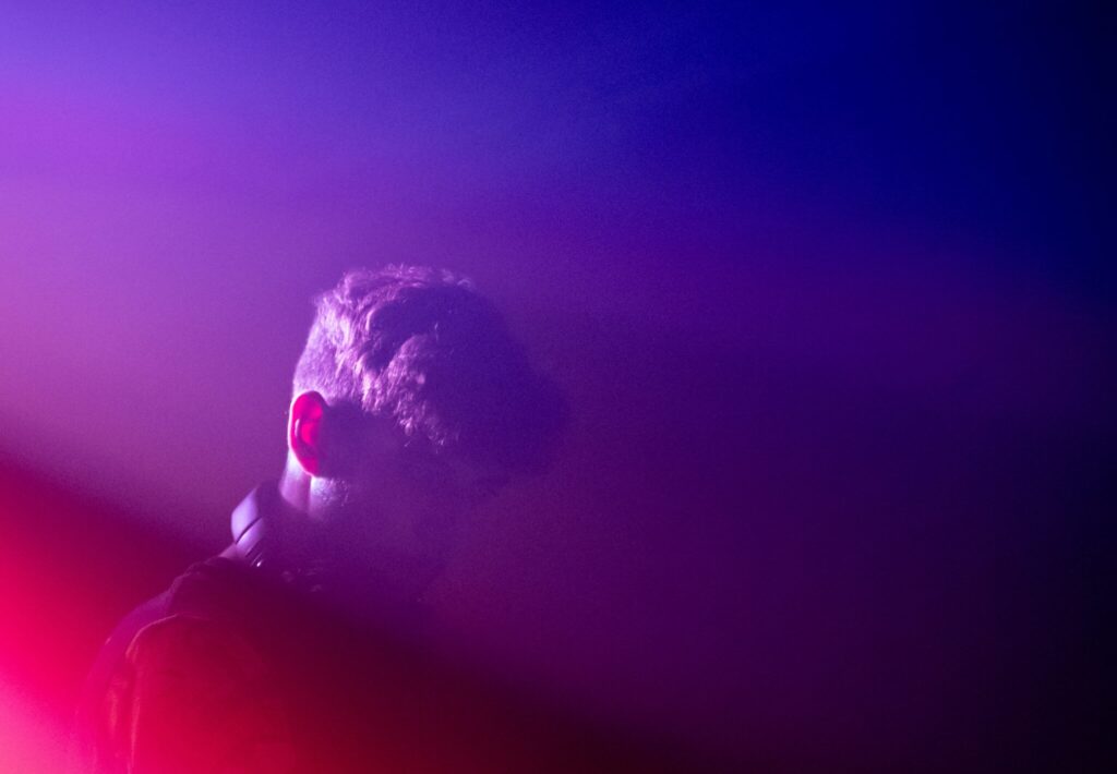 Persona de espaldas con luces que coinciden con el color de la bandera bisexual